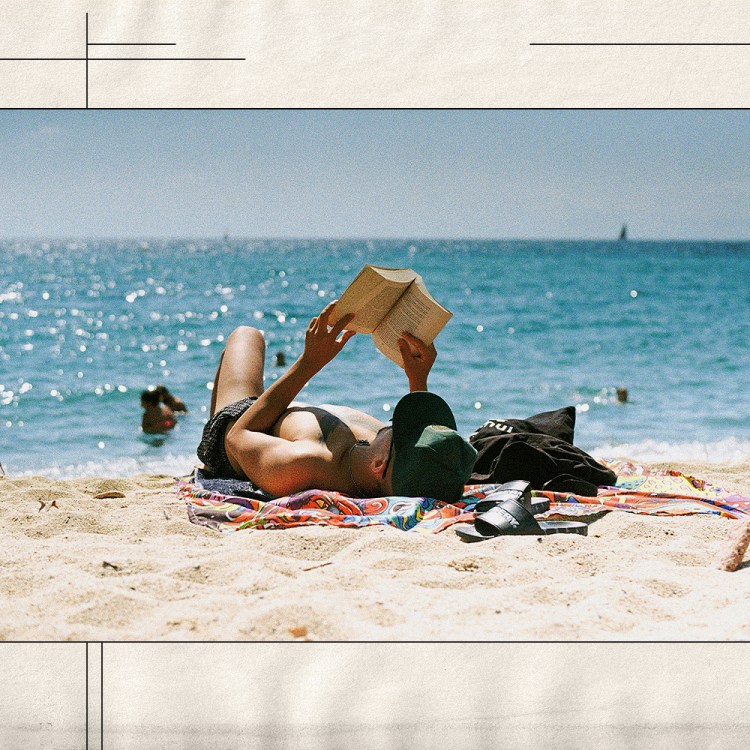 A man reading a book on the beach