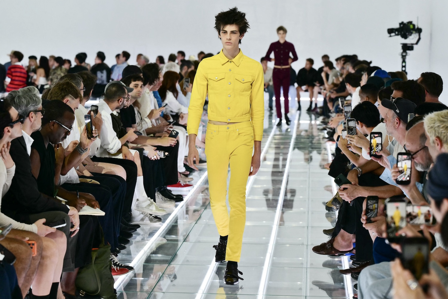 A model in yellow denim walks the runway during the Prada collection show