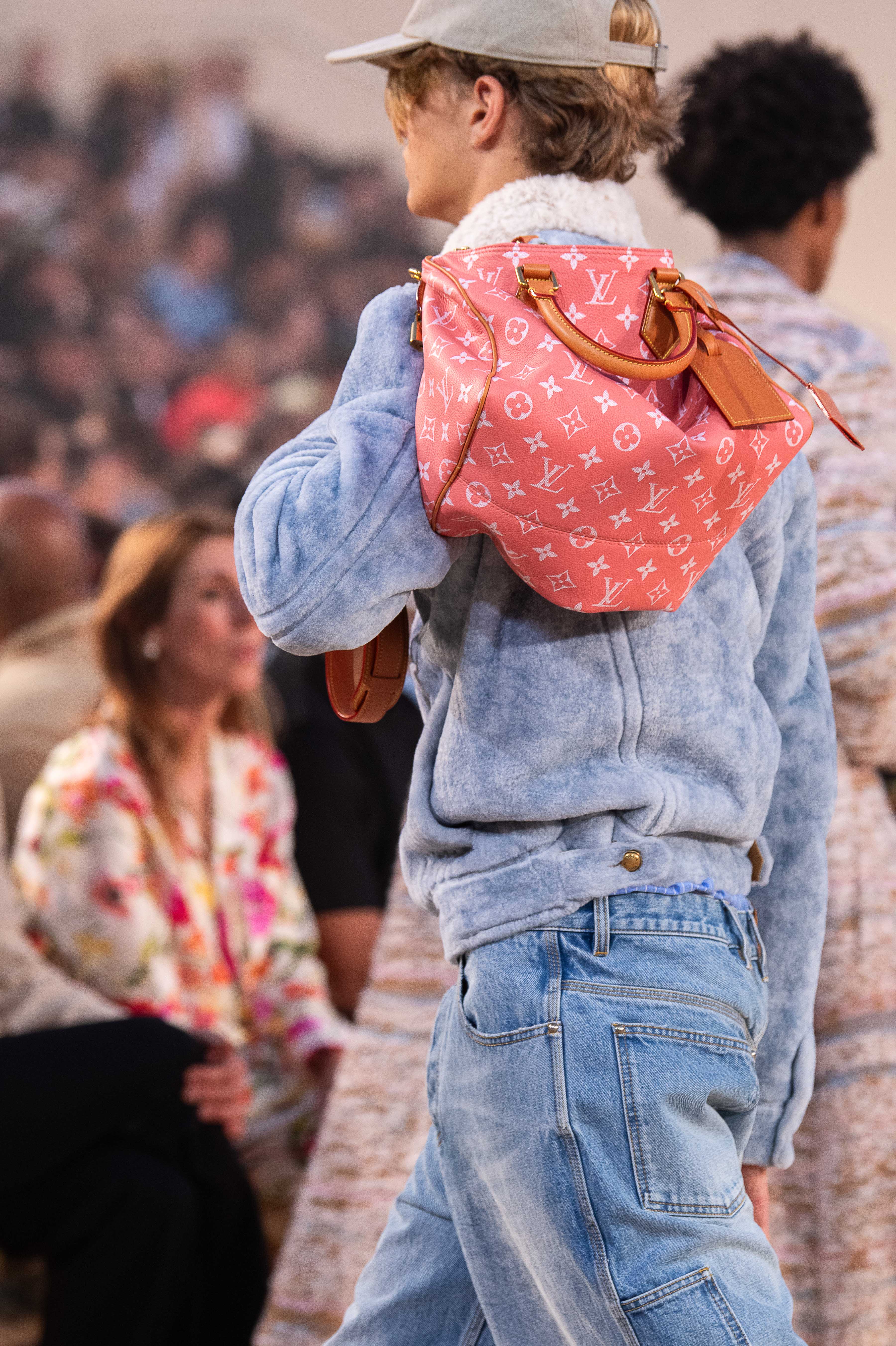 A model holding a red monogrammed bag at the Louis Vuitton Menswear Spring/Summer 2027 fashion show