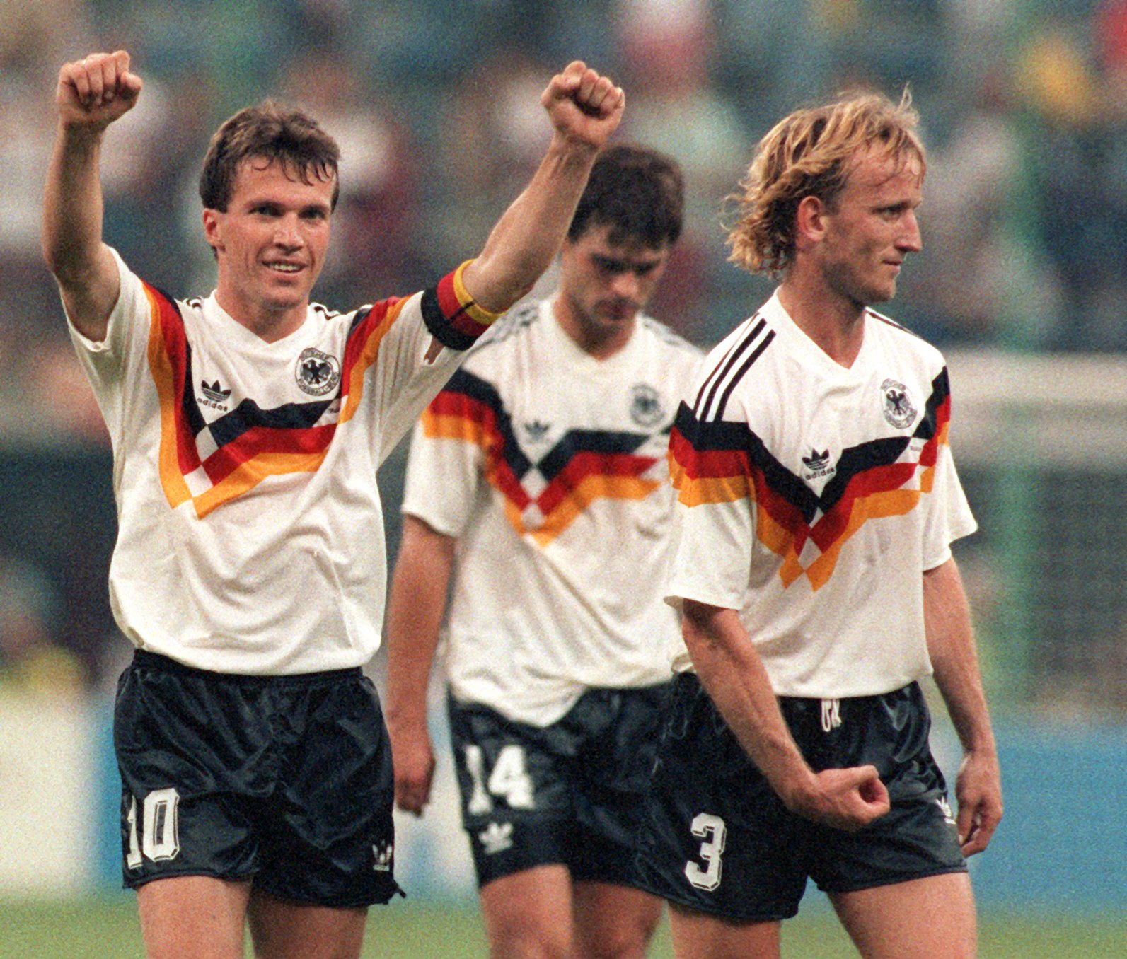 German midfielder and team captain Lothar Matthaeus (L) jubilates and victoriously gestures with his stretched arms and fists while he walks off the pitch with his fellow teammates German defender Thomas Berthold (C) and defender Andreas Brehme after the 1990 World Cup round of sixteen soccer game Germany against the Netherlands in Milan, Italy, 24 June 1990. Germany won the game 2-1 and qualified for the world cup quarter final. (Photo by Frank Leonhardt/picture alliance via Getty Images)