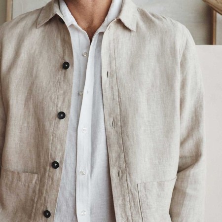 A model wearing a flax-colored Quince linen chore coat