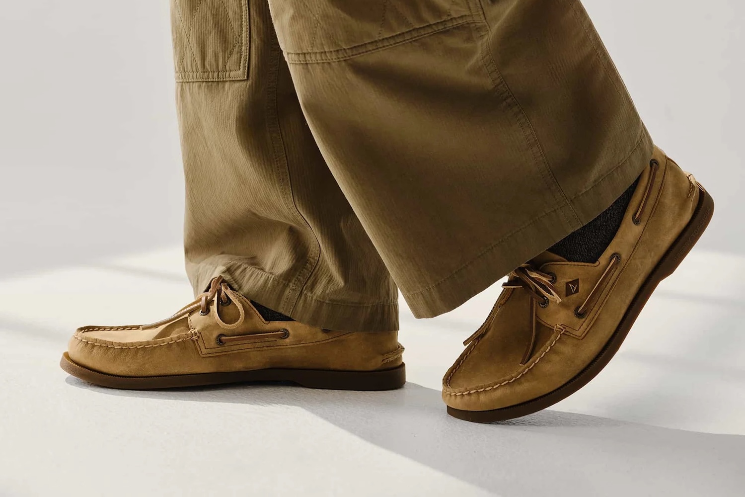 a model in a pair of tan pants and Sperry boat shoes