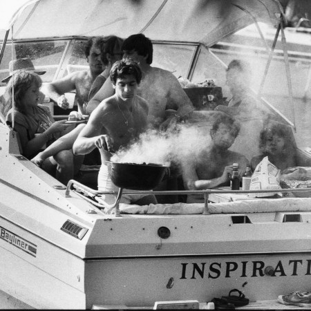 black and white photo of people on a boat with a grill