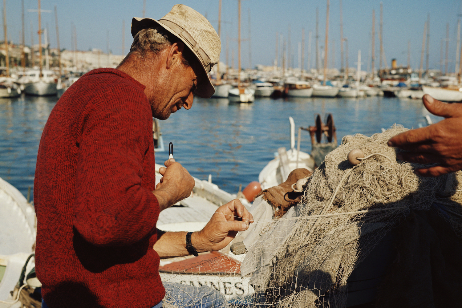 A fisherman tinkering with his nets.