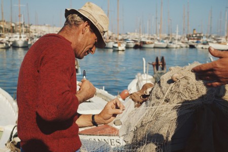 A fisherman tinkering with his nets.