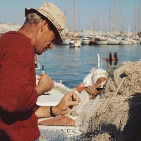 A fisherman tinkering with his nets.
