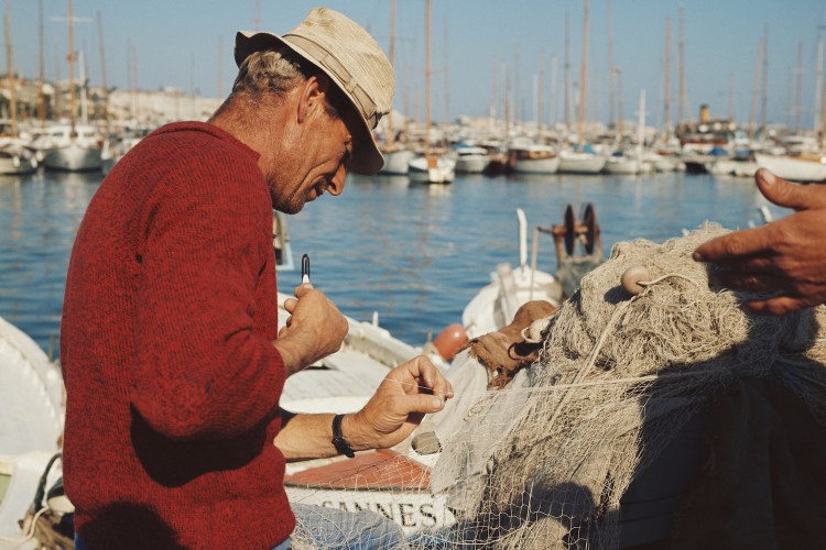 A fisherman tinkering with his nets.