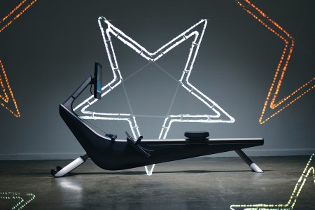 A rowing machine flanked by neon lights in the shape of stars