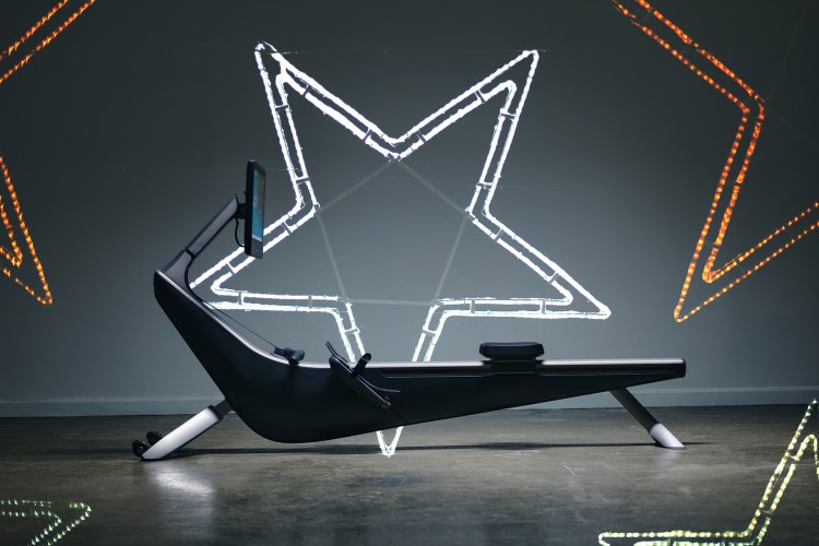 A rowing machine flanked by neon lights in the shape of stars