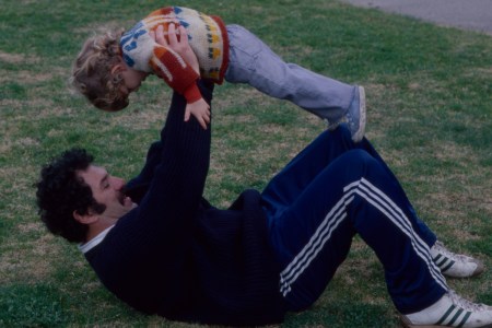 A man on his back, holding his son up.