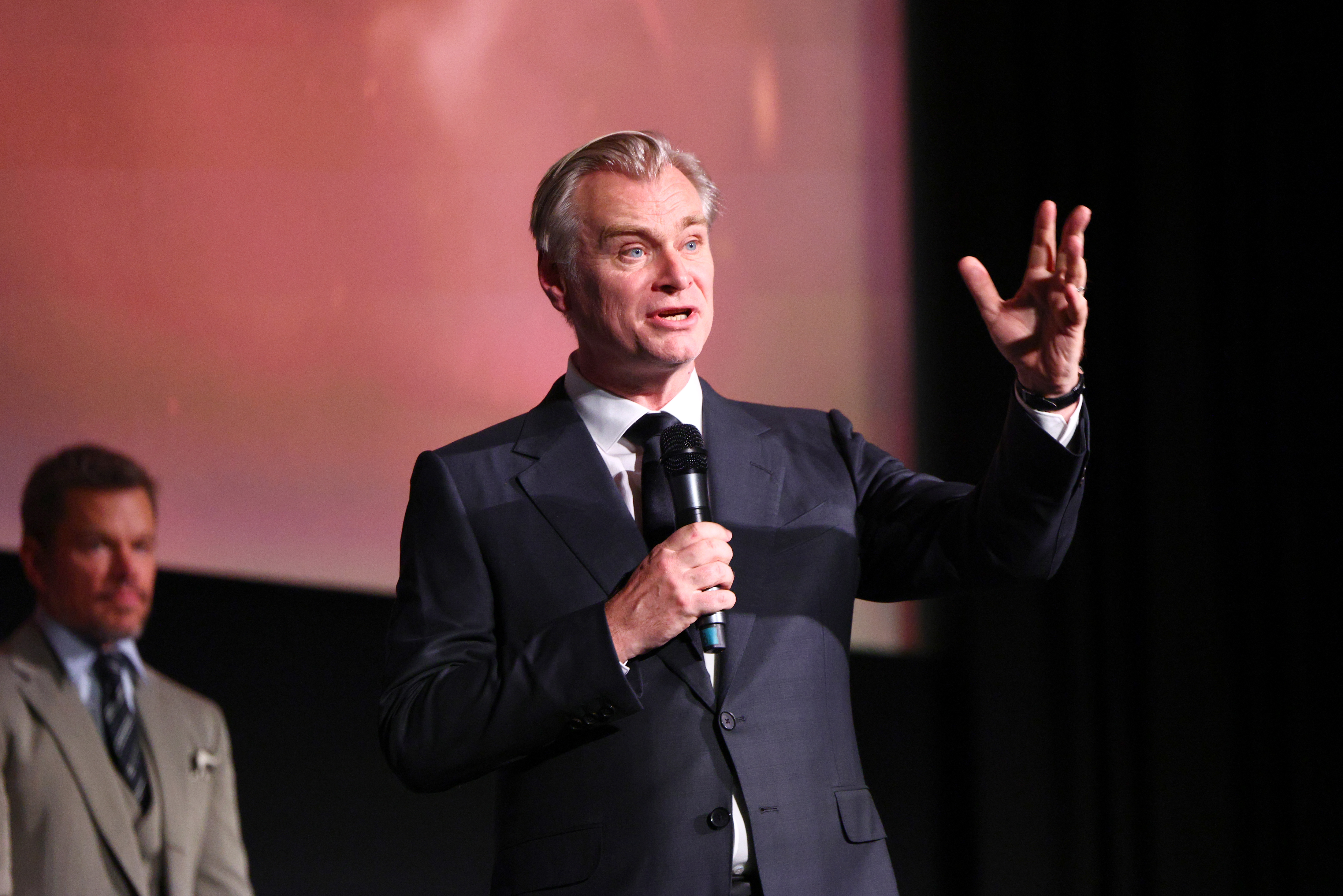 A man speaking into a microphone addressing an audience