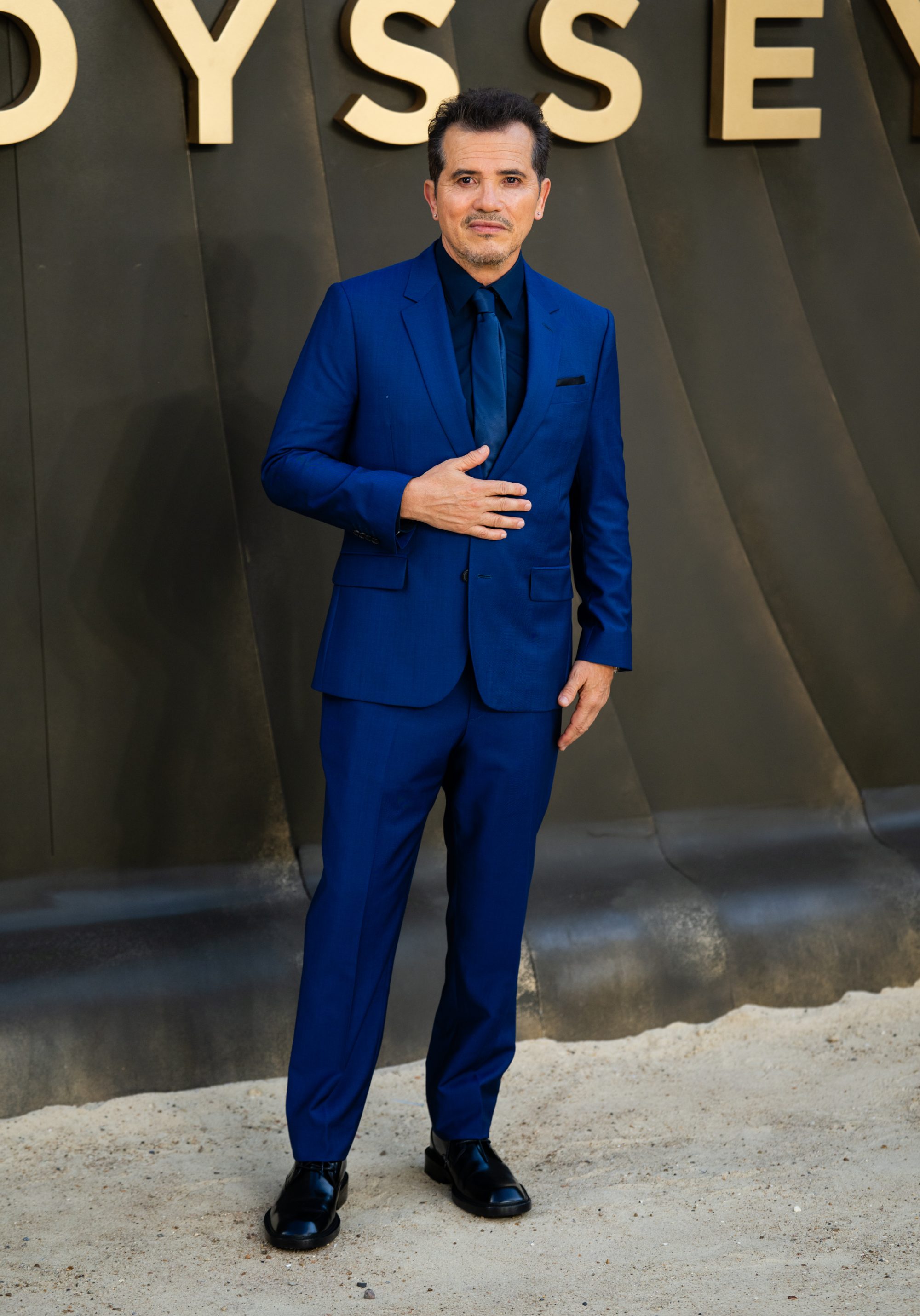 A man in a blue suit standing for a photo.