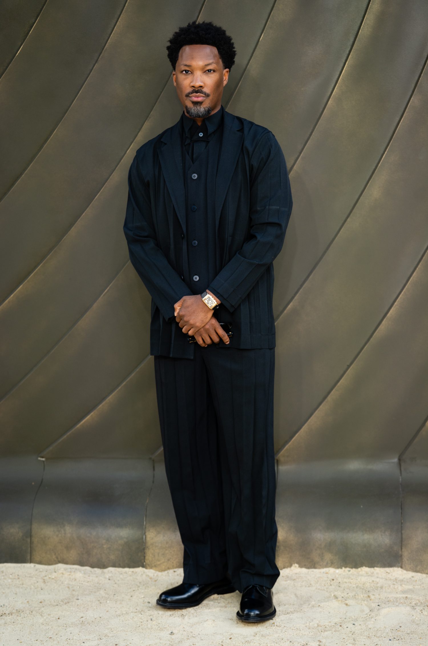 A man in a black suit standing for a photo.