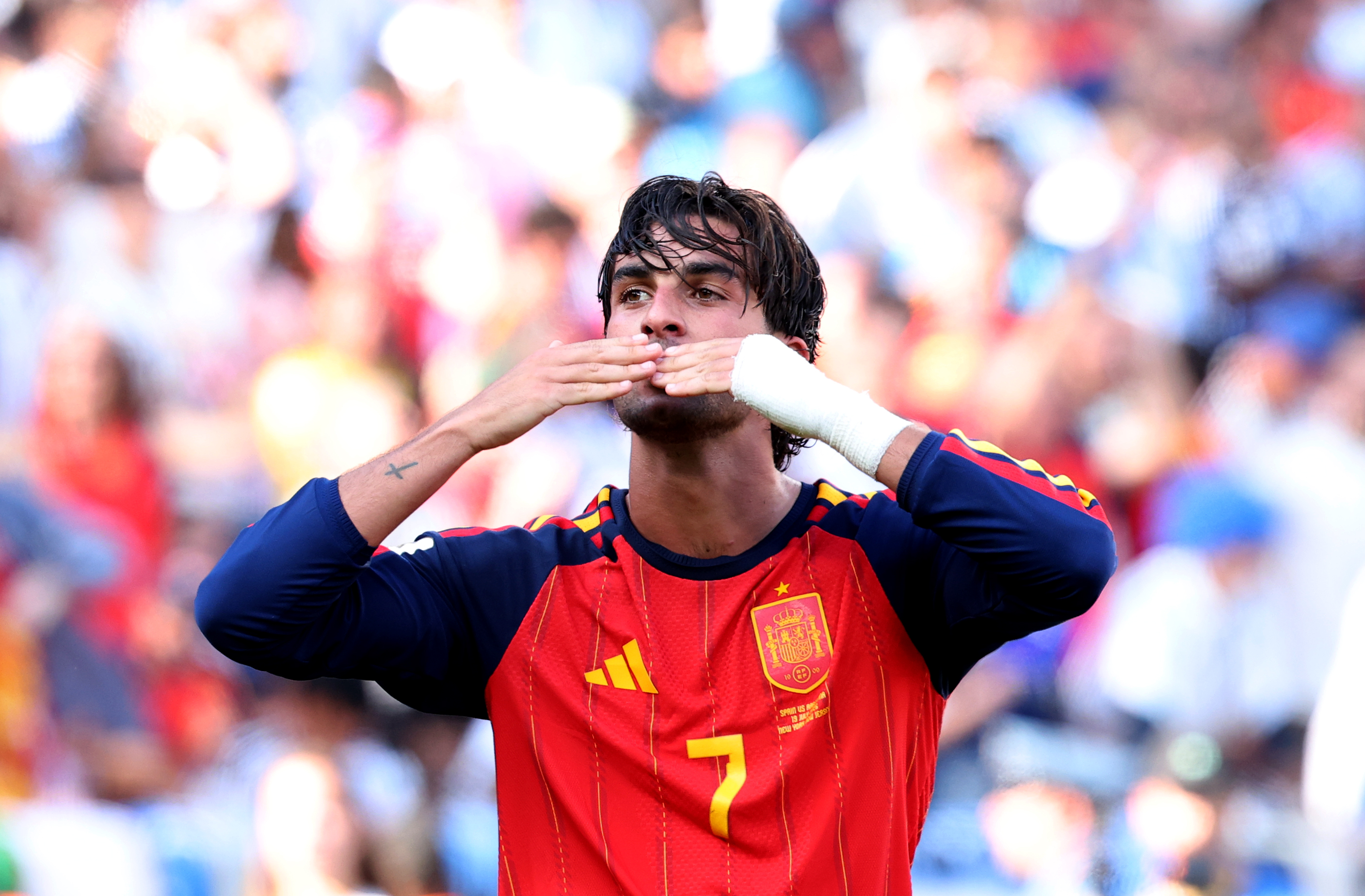a man in a red jersey blowing a kiss to the crowd