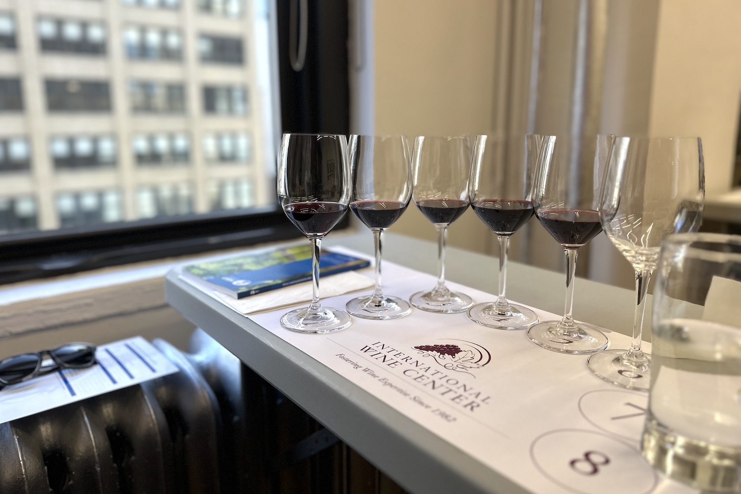 a lineup of red wines on a tasting mat at the international wine center in manhattan