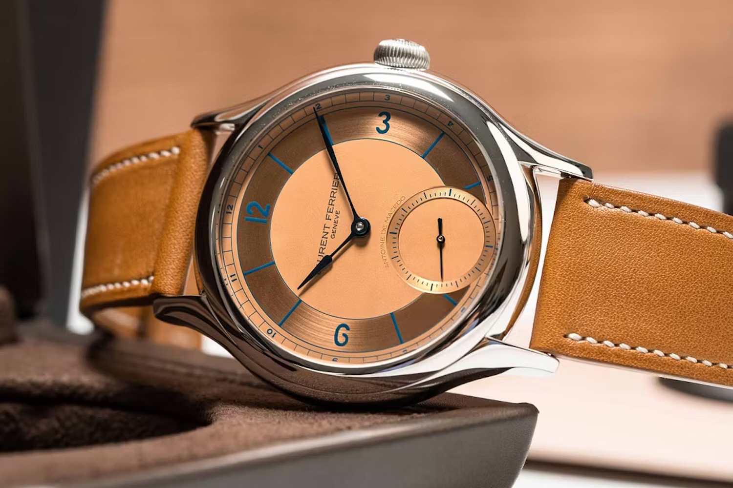 a salmon dial micro rotor watch on a leather strap
