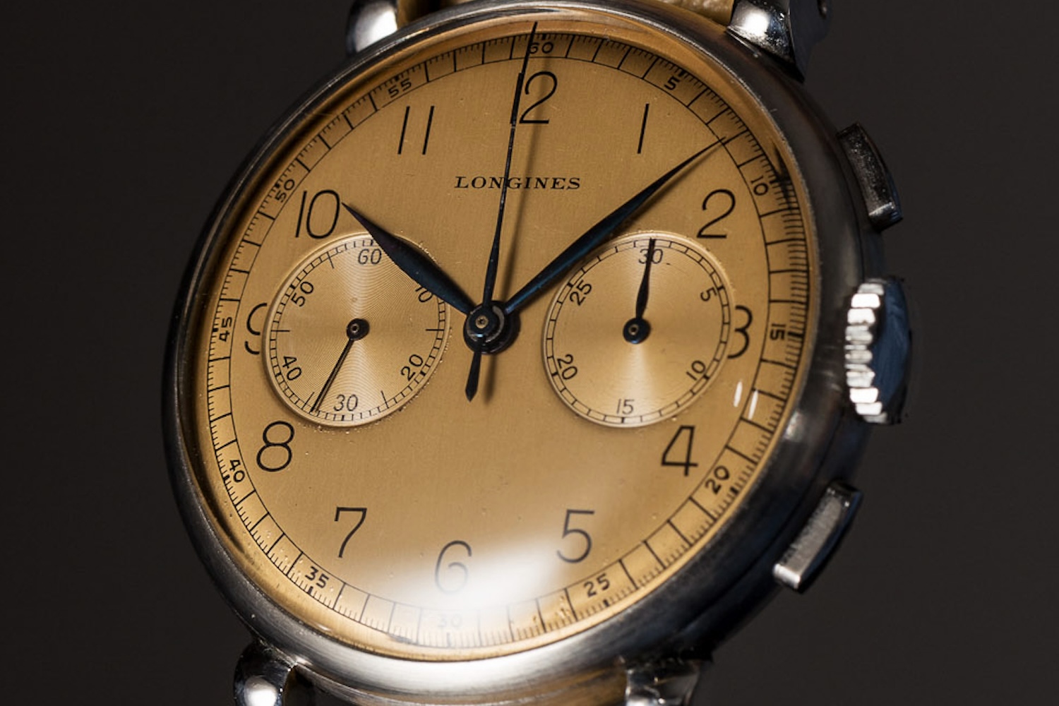 A watch with three hands, a salmon-colored dial, two subdials and the word "Longines" across the dial