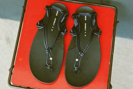A pair of black roped sandals on a red tray