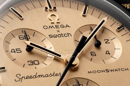 An up-close view of a golden watch face from the Omega x Swatch Moonswatch 1969