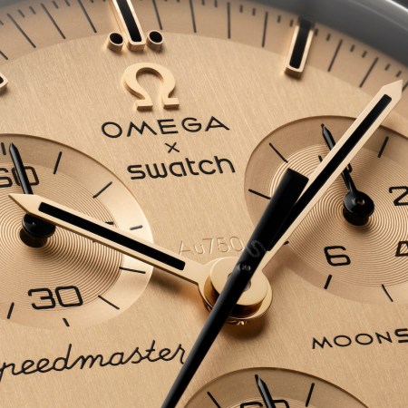 An up-close view of a golden watch face from the Omega x Swatch Moonswatch 1969