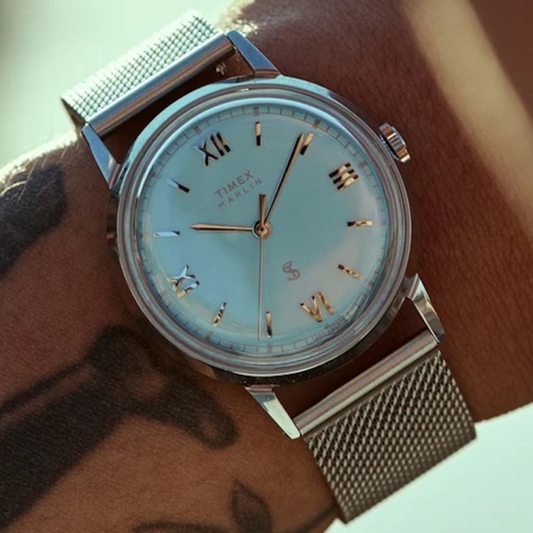 a blue face Timex x Todd Snyder watch on a man's wrist