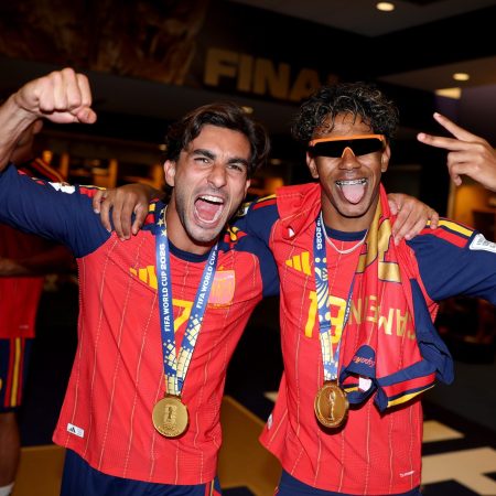 two men in red soccer jerseys cheering