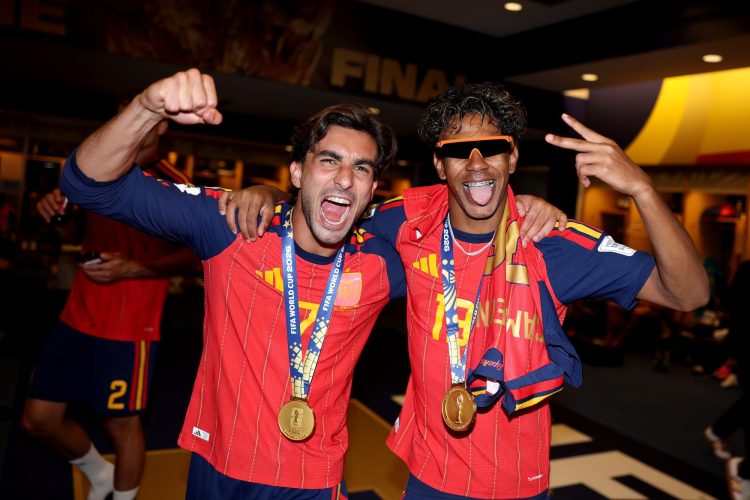 two men in red soccer jerseys cheering