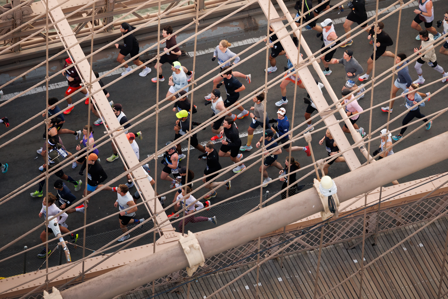 A group of runners cross the Brooklyn Bridge.