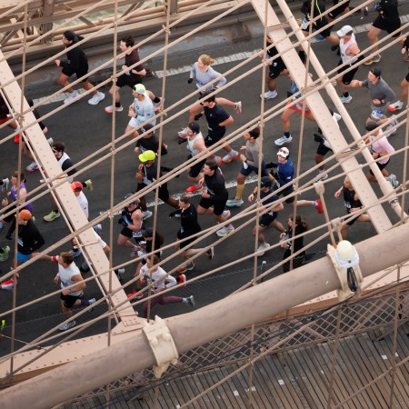 A group of runners cross the Brooklyn Bridge.