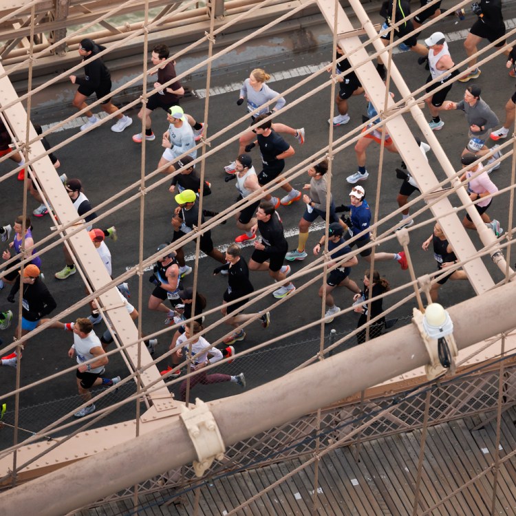A group of runners cross the Brooklyn Bridge.