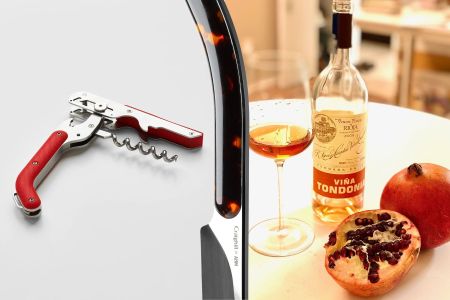 A wine key with a red handle on the left, a Champagne saber in the middle, and on the right a table with a bottle of wine, a wine glass and a pomegranate cut in half to show the seeds