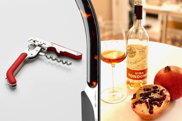A wine key with a red handle on the left, a Champagne saber in the middle, and on the right a table with a bottle of wine, a wine glass and a pomegranate cut in half to show the seeds