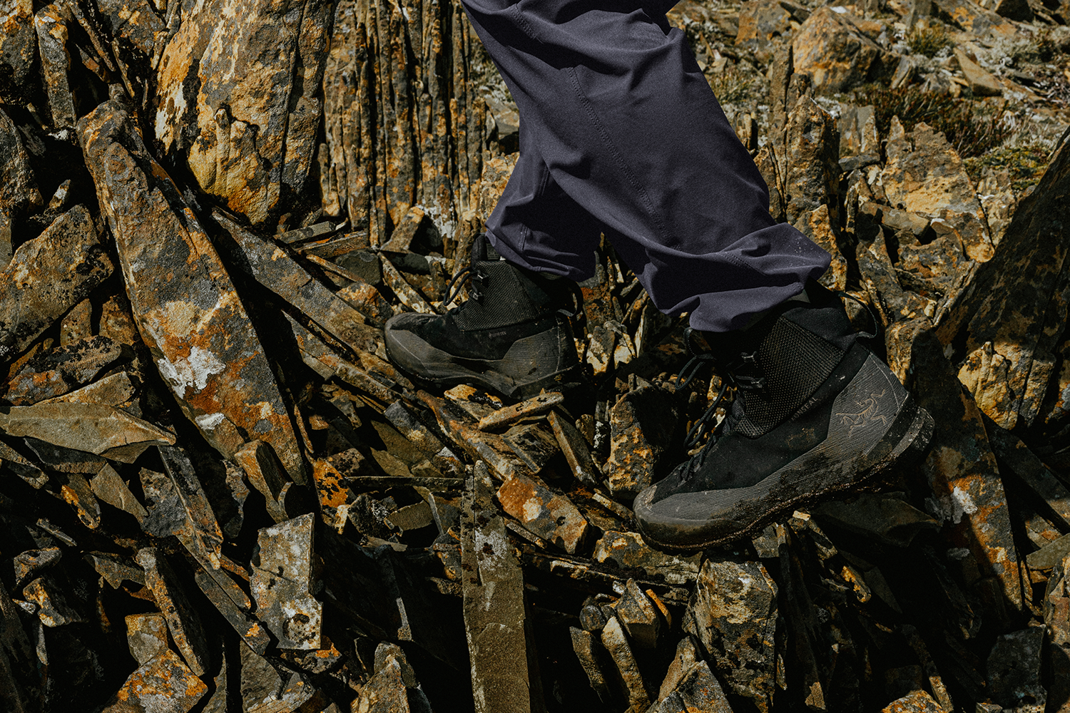 Man hiking in Arc'teryx boots on a rocky terrain.