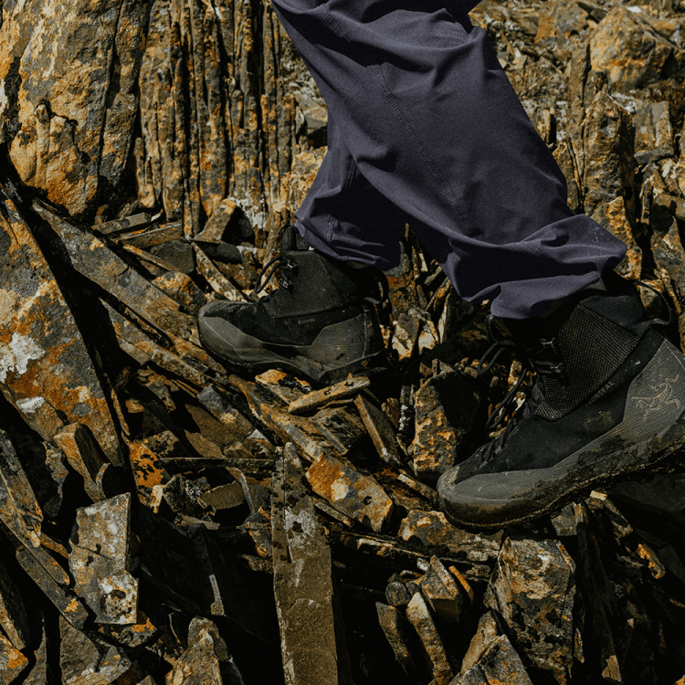Man hiking in Arc'teryx boots on a rocky terrain.