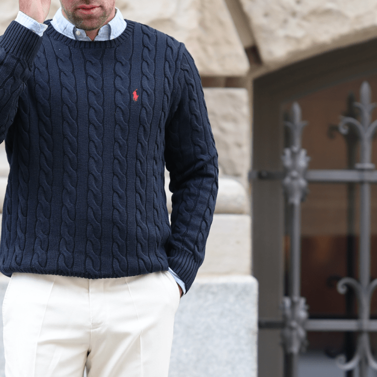 A model in a navy cable-knit Polo Ralph Lauren sweater.