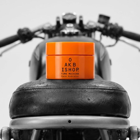 a moisturizer in an orange jar on a motorcylce