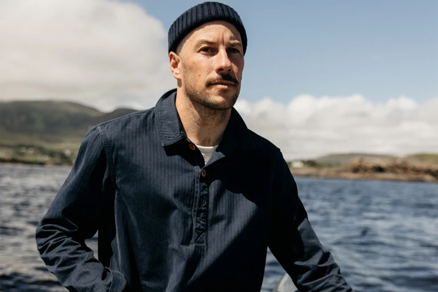 Man driving a boat in finisterre outfit.